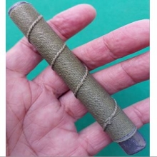 ตะกรุดเนื้อตะกั่วถักเชือกสีเขียว ยาวสี่นิ้วกว่า